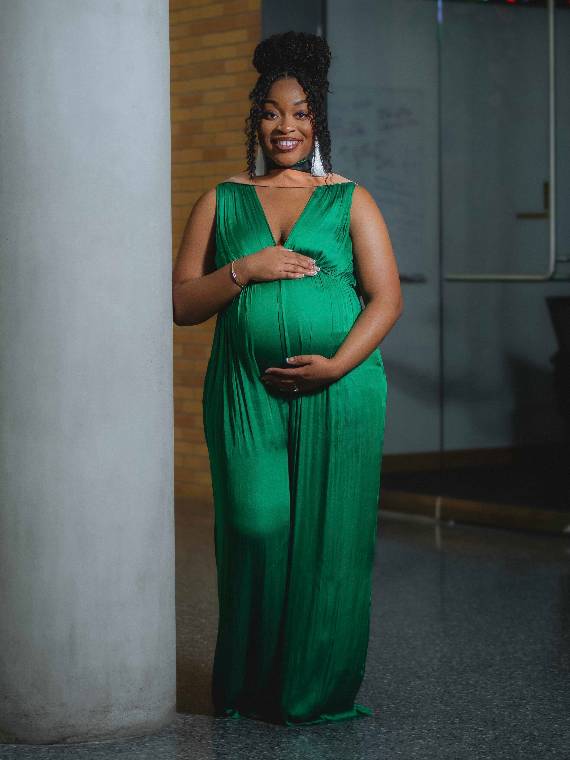 Robyne Ciza poses in the Business building wearing a green gown.