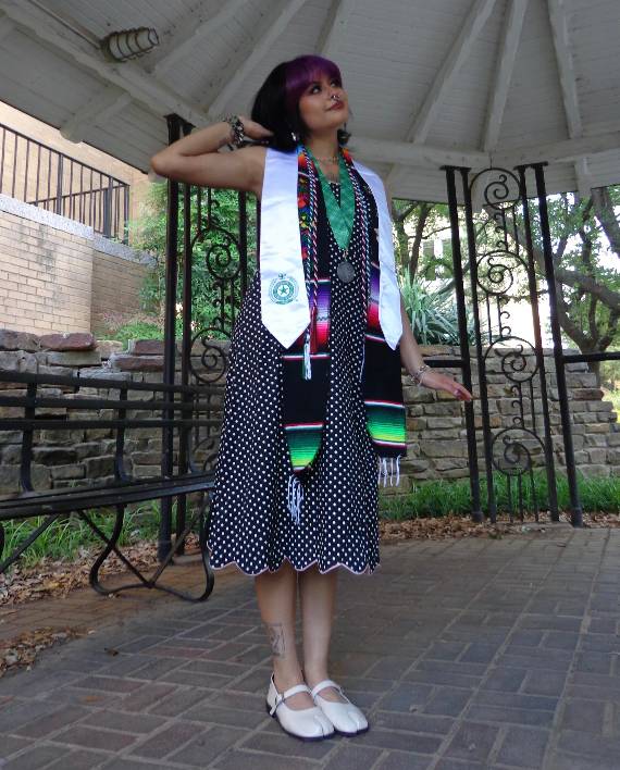 Photo of Stephanie Villagomez wearing a graduation stole in a gazebo.