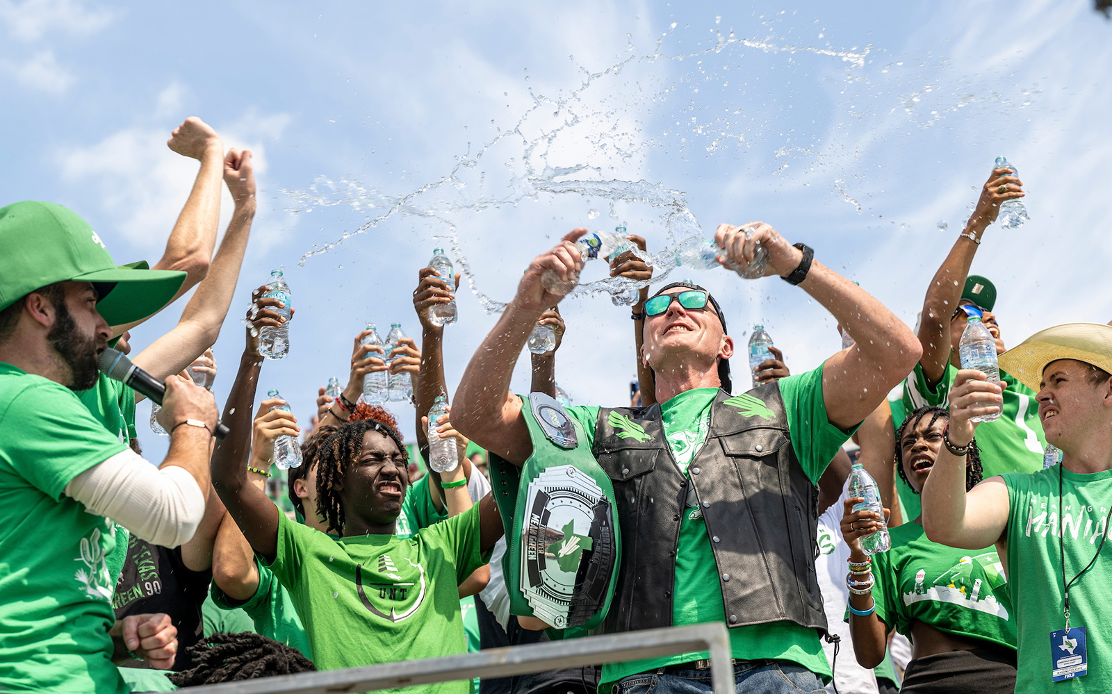 Mean Green fans celebrating and spraying water in the stadium