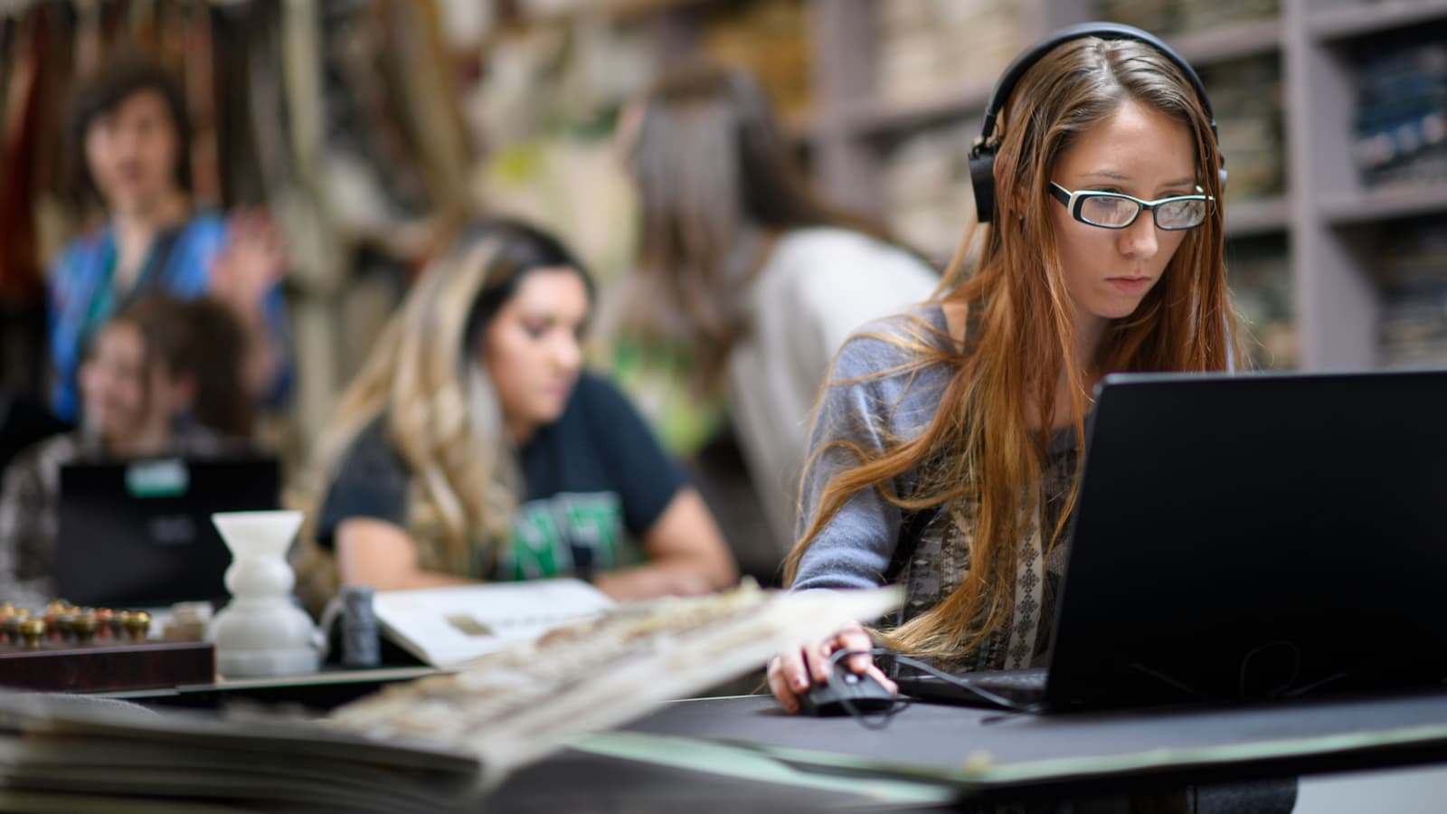 A merchandising student works on a laptop in the lab.