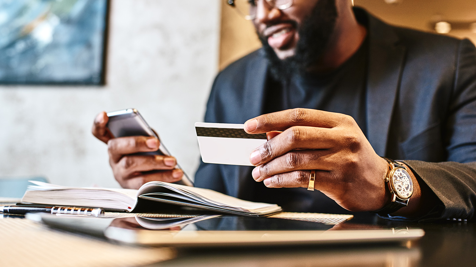A man holds his smartphone and credit card