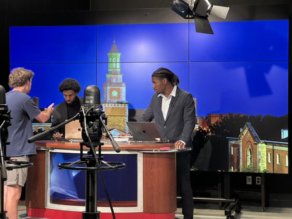 Students at a sports news desk