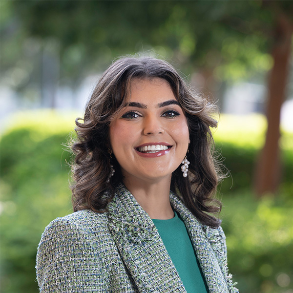 Woman wearing a tweed blazer smiling. 