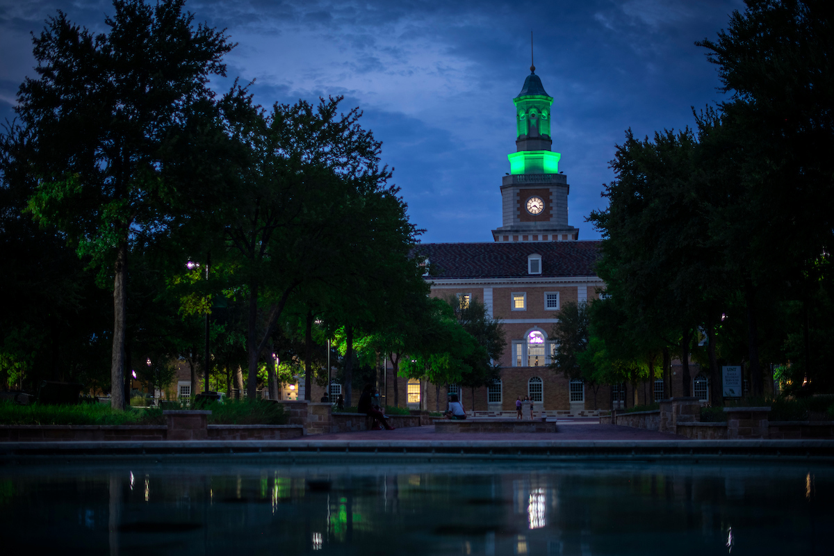 Administration Building at night with tower lit green