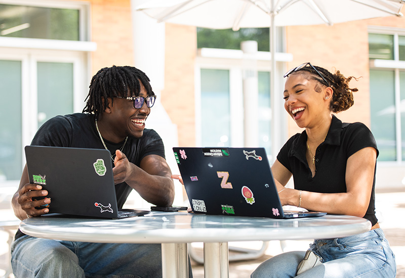 Students at the UNT Union on their laptops. 