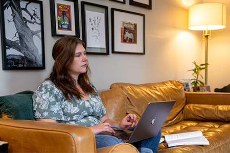 A student studying with her laptop and notes