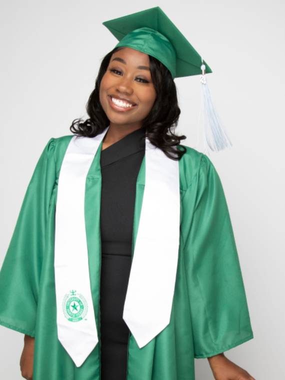 Jayla Wilson poses in her green commencement regalia