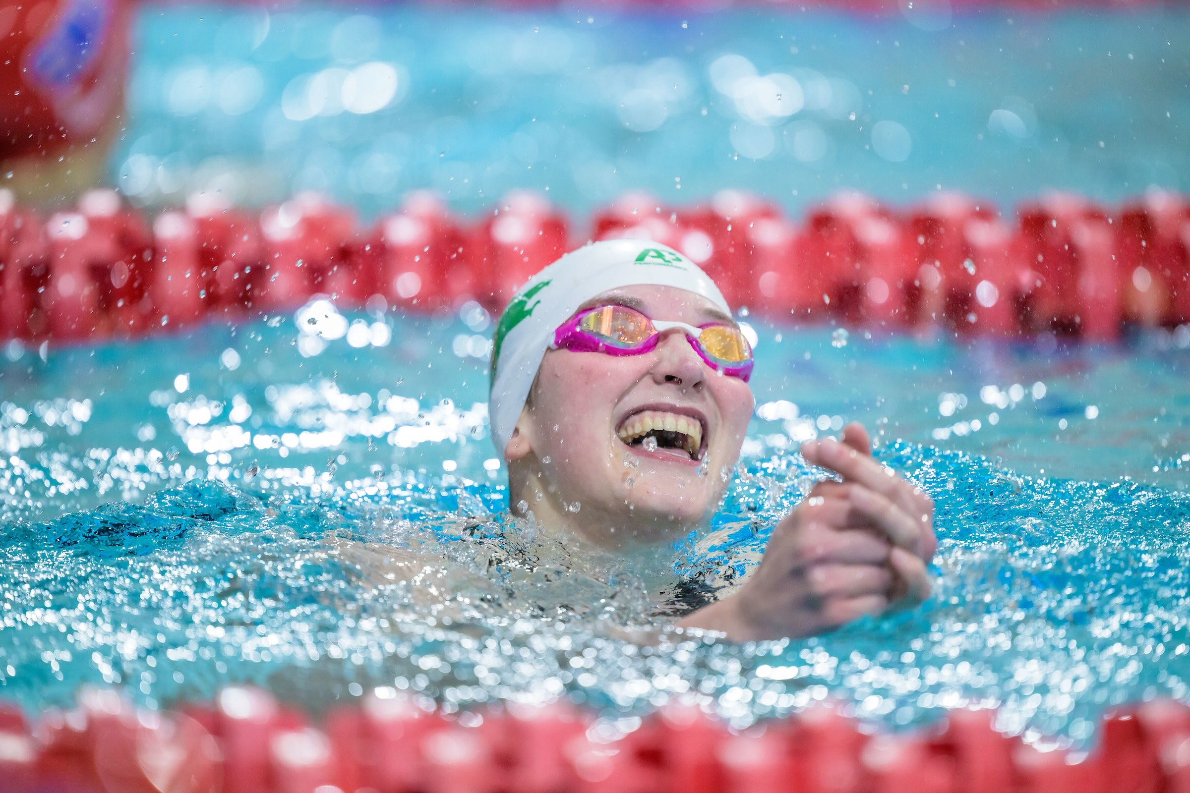 Noelle Marsh in a pool wearing a swim cap and goggles.