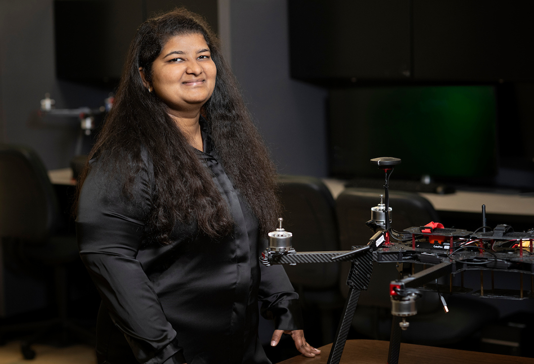 Jaya poses with a drone in a lab