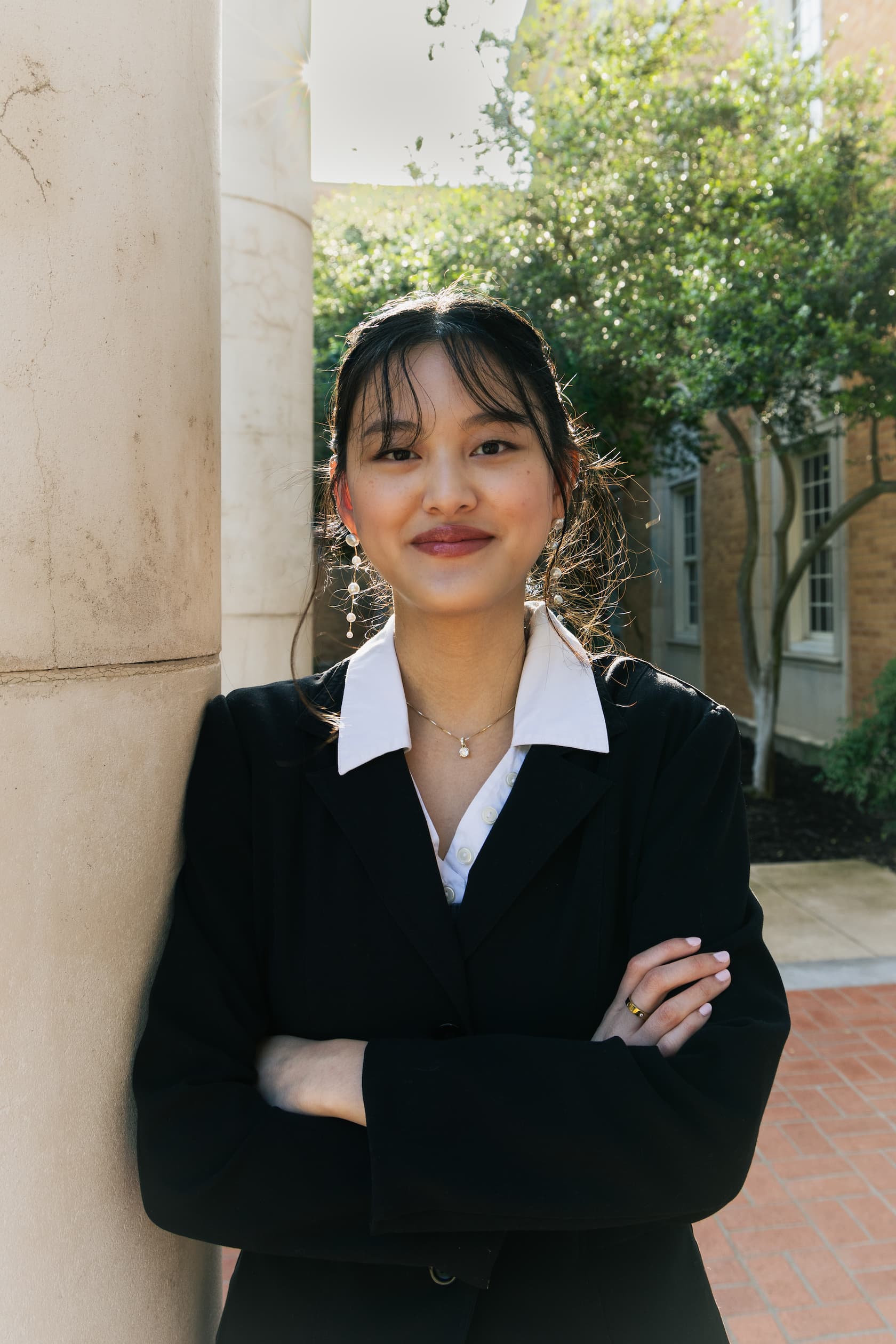 Abby Nguyen posses between two columns on campus