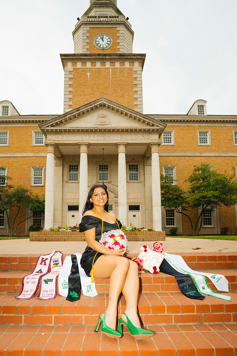 Jennifer Estrada poses in commencement regalia on UNT steps