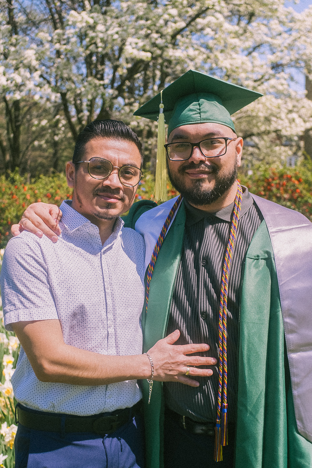 Tom Gomez poses in commencement regalia with his partner