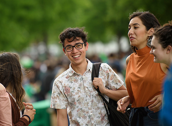 UNT student smiling while talking to other students. 