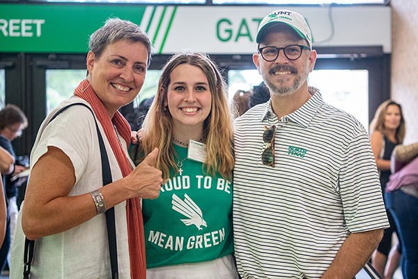 UNT student smiling with parents. 