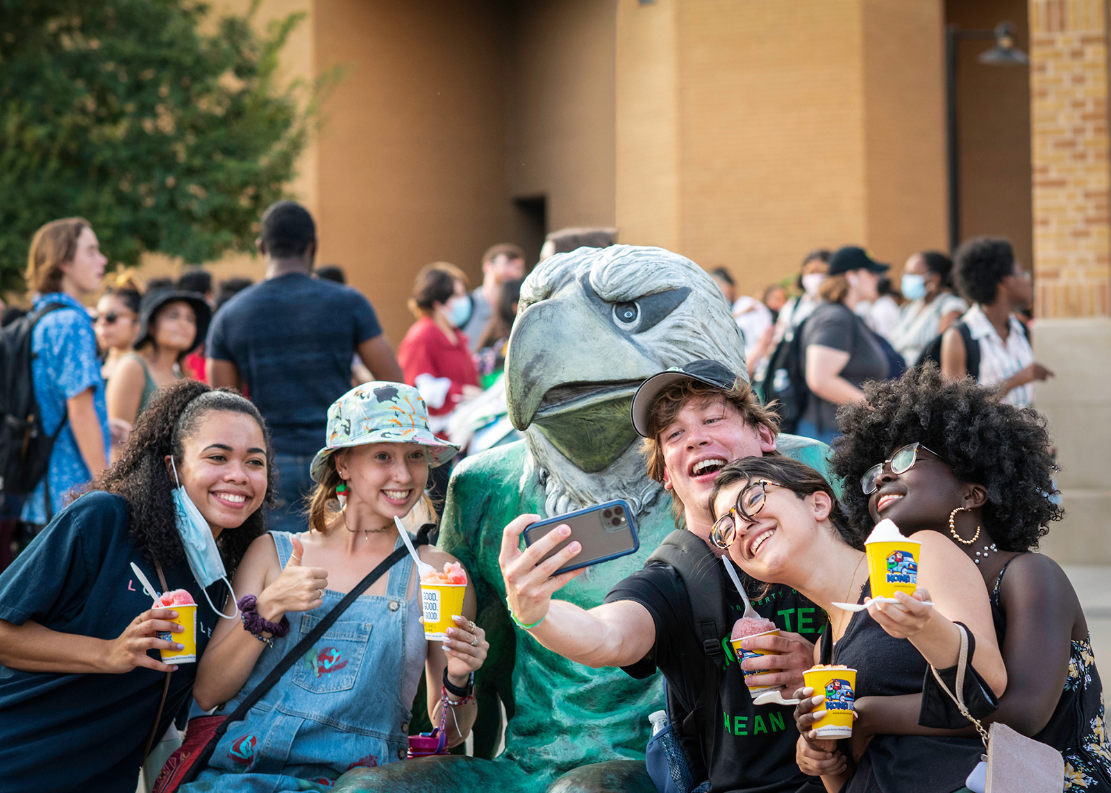 Students taking a picture with Scrappy the mascot. 