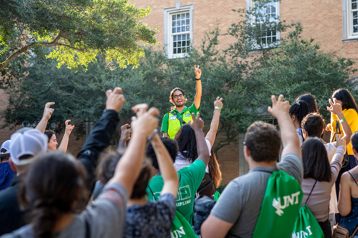 UNT orientation leader standing with incoming students. 