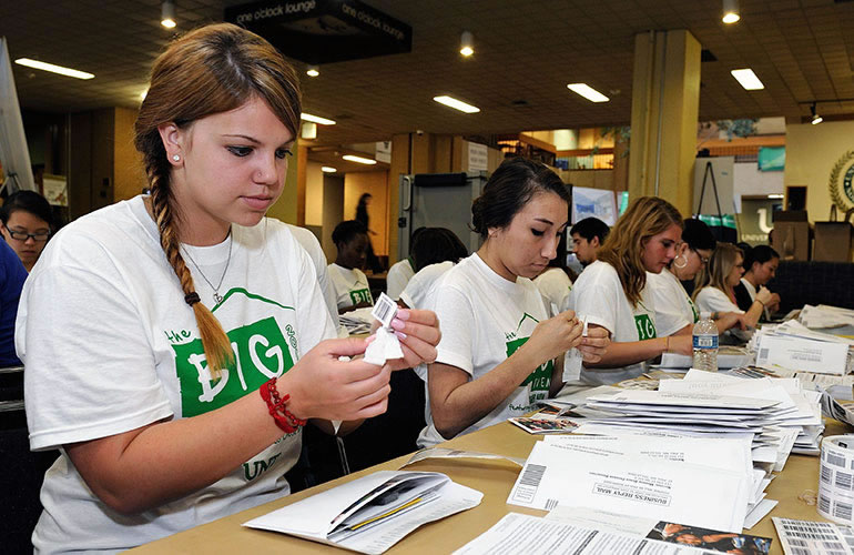 Students putting together mailers while volunteering at the Big Event.