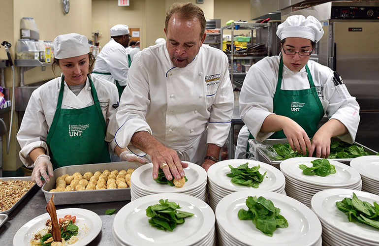 Chef Salerno teaching students how to plate gourmet meals in the CMHT kitchen.