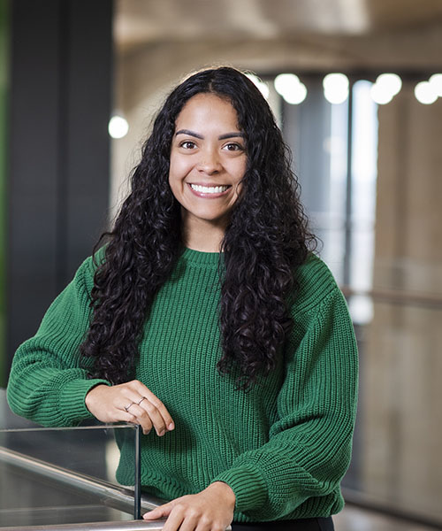 A woman wearing green sweater and smiling