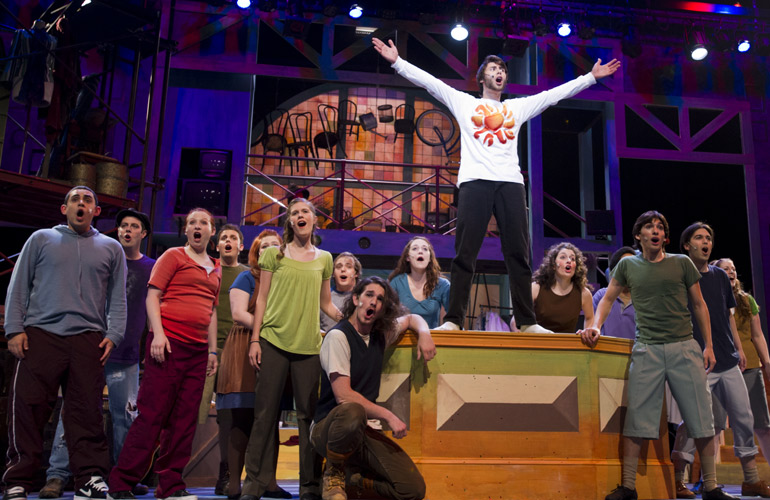Students performing a play on stage.