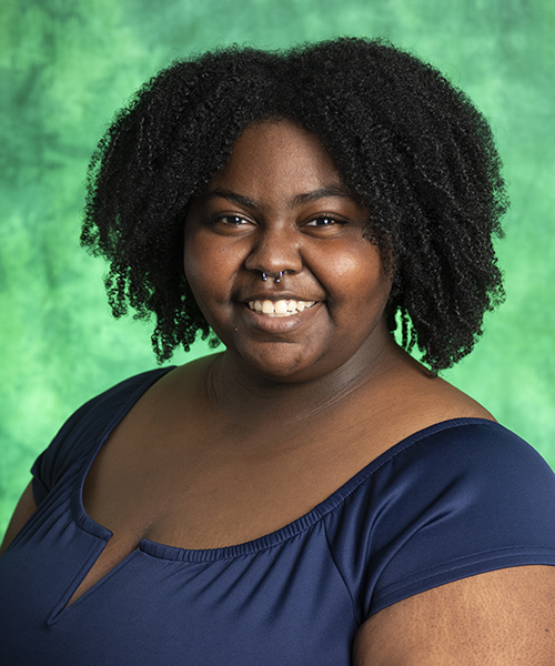 Woman wearing a green blouse smiling. 