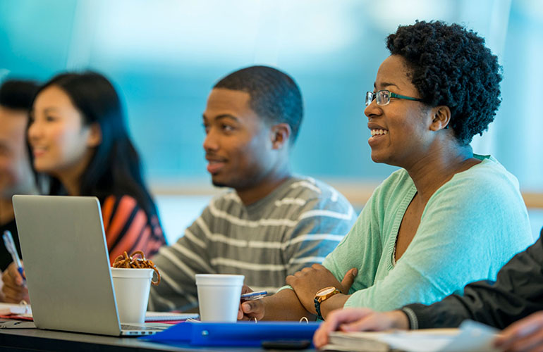 Students in a classroom listening to a presentation.