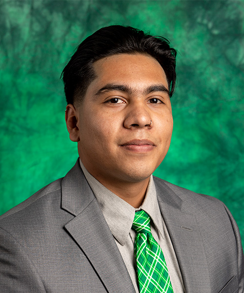 Man wearing gray suit with green tie smiling. 