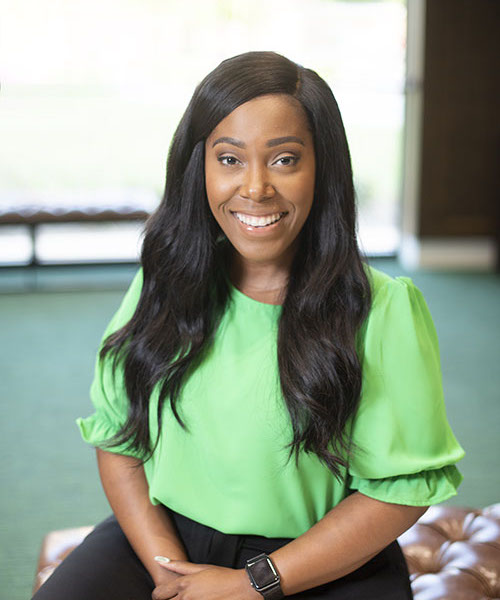 Woman wearing a green blouse smiling. 