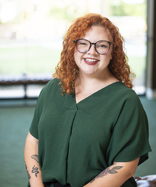 Woman wearing a green blouse smiling. 