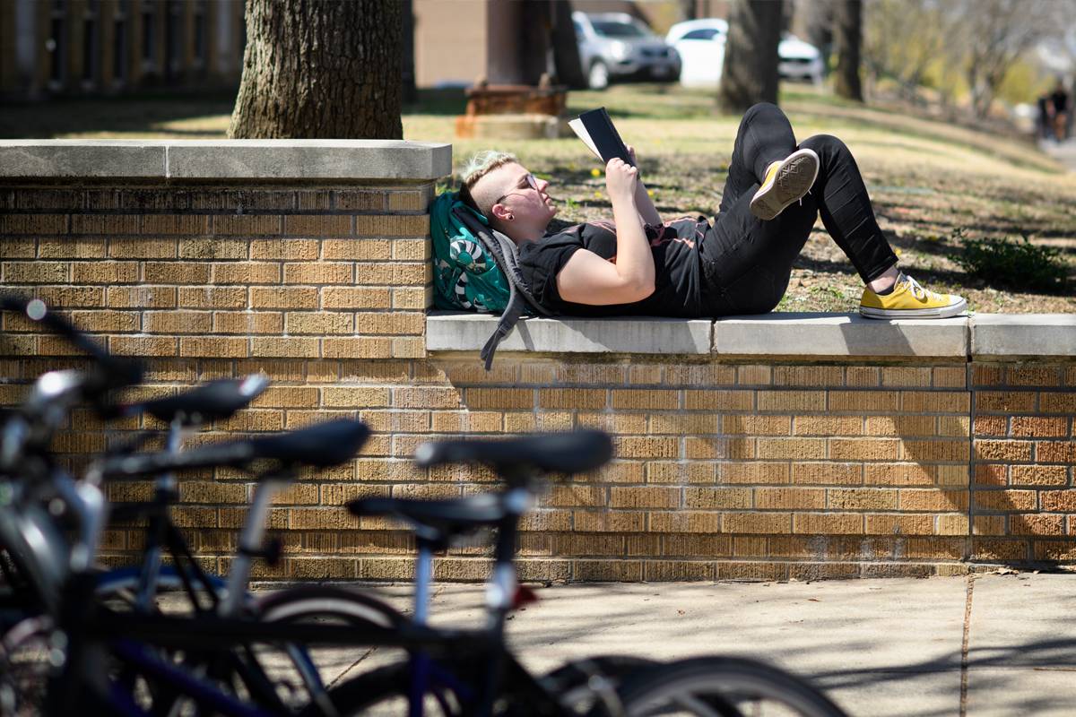 Student reading on campus